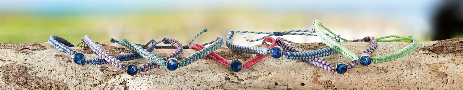 Ocean Drop Bracelets in 5 different colorways along a piece of driftwood 