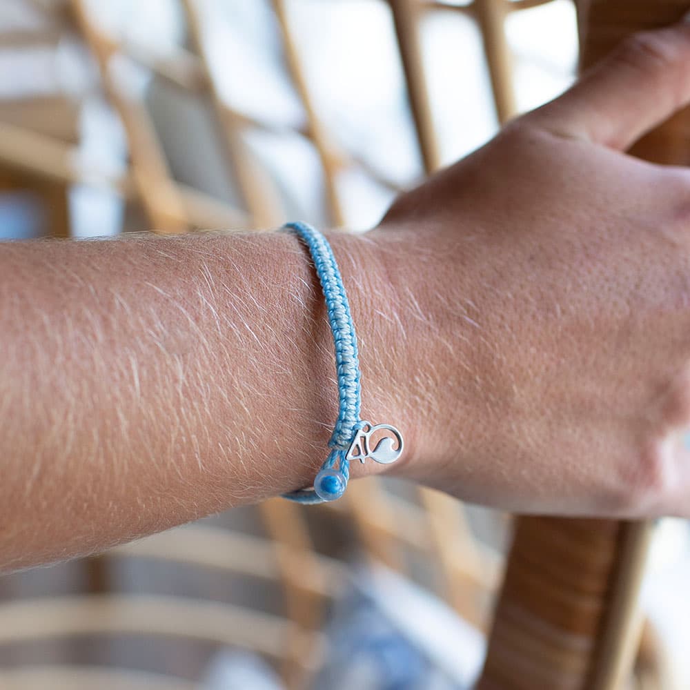 A Closeup of a Person Wearing the 4ocean Beluga Whale Braided Bracelet
