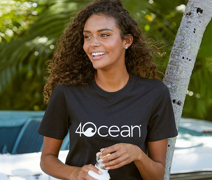 4ocean logo unisex men's and women's t-shirt on a woman - black