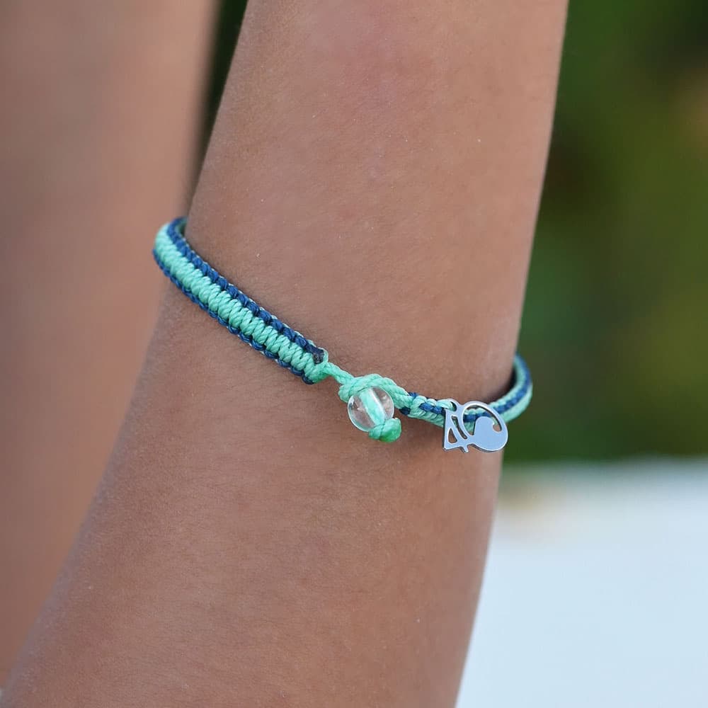 A closeup of a person wearing the 4ocean Stingray Limited Edition Braided Bracelet