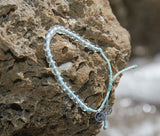 Olive Ridley Sea Turtle Beaded Bracelet on a beach rock.