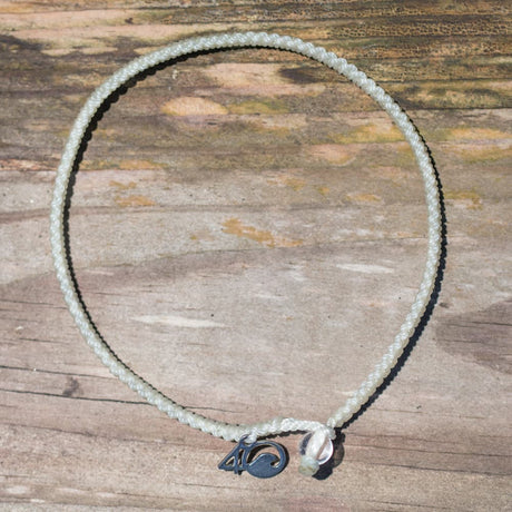 4ocean Polar Bear Braided Bracelet with a wood background