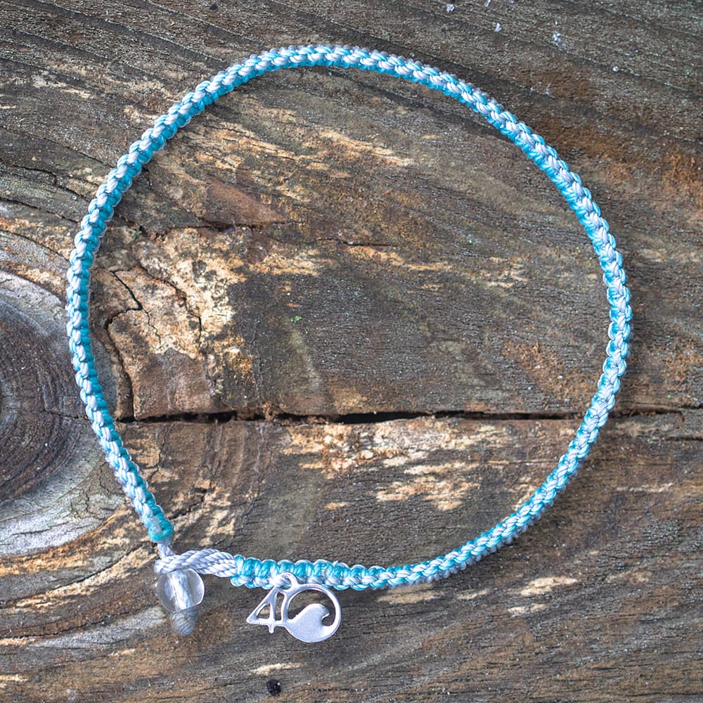 4ocean Dolphin Braided Bracelet on a Wooden Plank