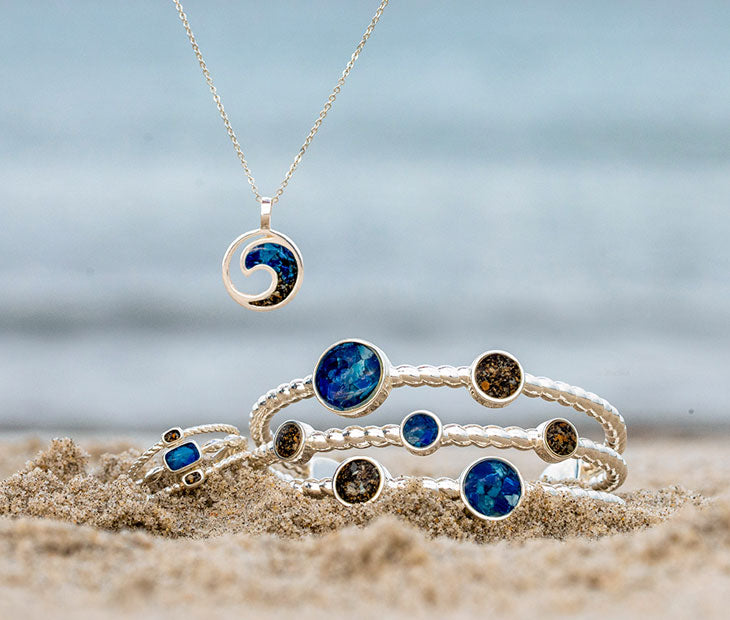 A set of Dune Bali Ring, wrist cuff, and necklace on the beach.