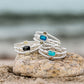 Dune Florida Ring, Dune Bali Ring, and Dune Hawai'i Ring stacked on a rock on the beach