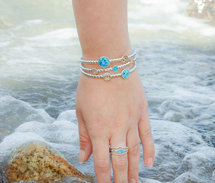 Dune Hawaii Bracelet and Ring on a woman's arm at the beach