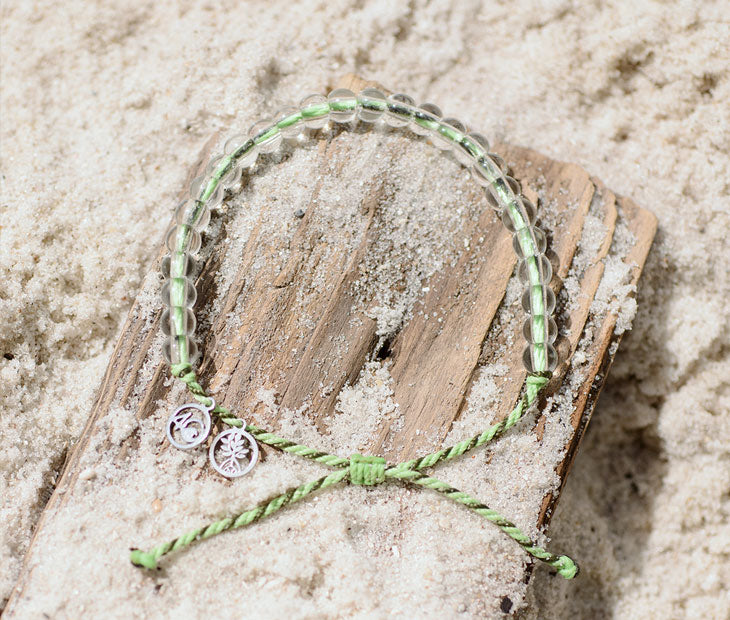 4ocean Earth Day Beaded Bracelet 2022 - green. On drift wood.
