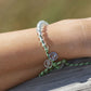4ocean Earth Day Beaded Bracelet 2022 - green. On wrist of female model.