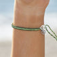 4ocean Earth Day Braided Bracelet 2022 - green. On wrist of female model.
