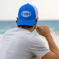 Man wearing the 4ocean surfer badge trucker hat