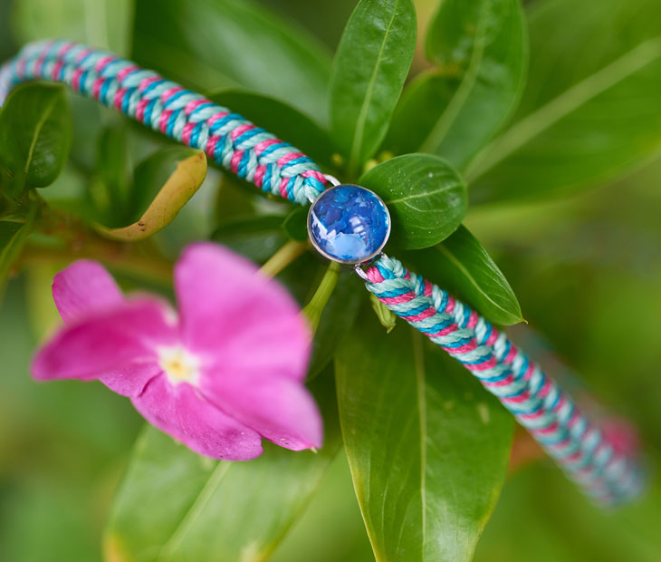 4ocean Ocean drop bracelet. Pink, green and teal braided cord with stainless and blue bezel. 