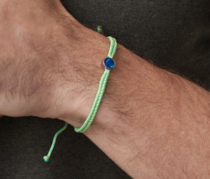 4ocean Green Ocean Drop Bracelet. Green and yellow cord with attached blue and stainless bezel.