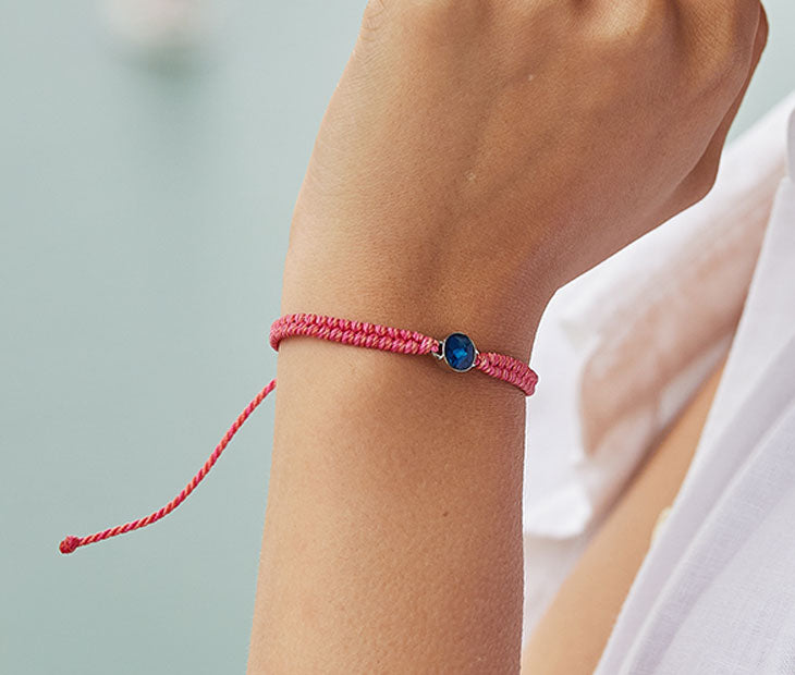 4ocean Pink Ocean Drop Bracelet. Pink braided cord with stainless and blue bezel.