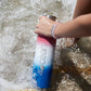 Large Reusable Bottle - Patriotic Ombre in ocean with female model.