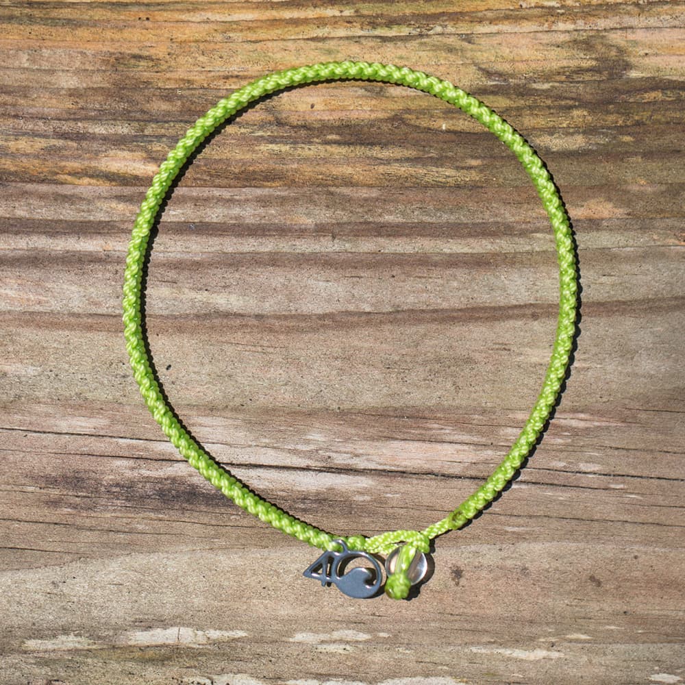 4ocean Sea Turtle Braided Bracelet on a wooden background