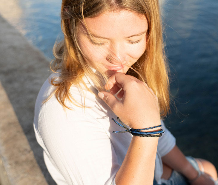 Shark Stack bracelet being modeled on a female with the water in the background 