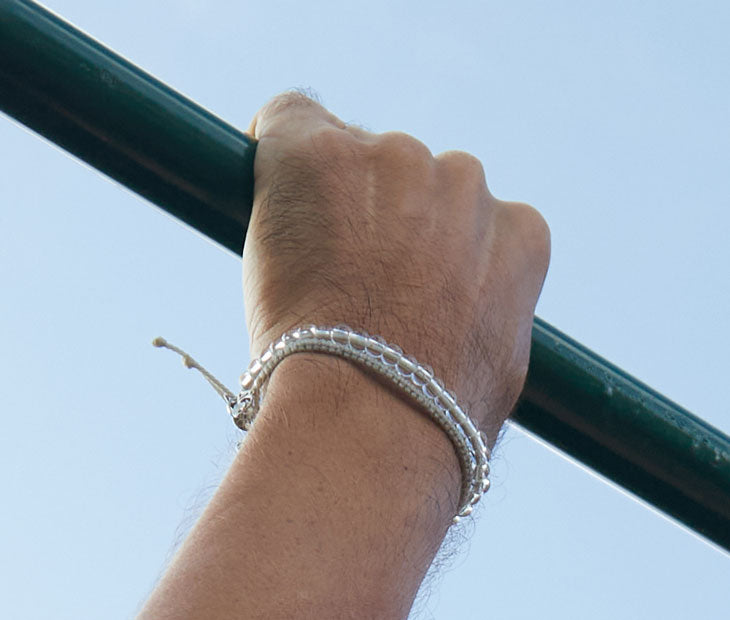Tiger Shark beaded bracelet being modeled on a males wrist grasping a bar overhead 